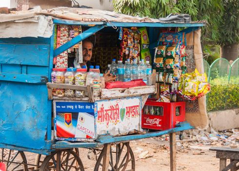 AGRA, INDIA - CIRCA FEBRUARY 2011 - Street vendor sells basic grocery products in a typical small booth on wheels.