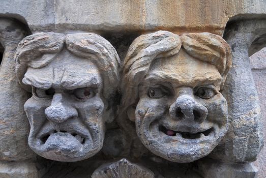 HELSINKI, FINLAND - CIRCA SEPTEMBER 2010: Fresco of angry and happy male's face set in stone. Close up of mural statue in the wall of a business in downtown Helsinki. The two faces look at each other.