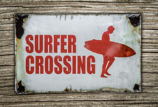 Vintage Red Retro Surfer Crossing Warning Sign On Wooden Background In Hawaii