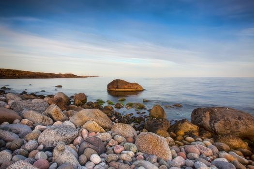 Sunset over the rolling stones of the Norwegian coast, Moelen