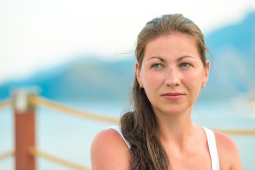 portrait of a beautiful young brunette on the pier