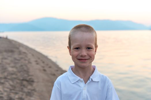 Portrait of a little boy on the beach at sunrise