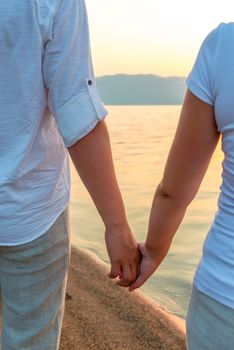 couple holding hands on the shore