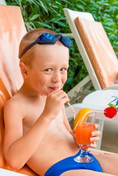 cheerful boy drinks juice at resort