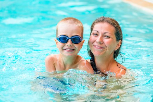 woman with her son in the pool swimming