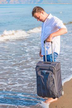 young man alone on an island with a suitcase