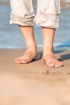 bare feet in the men's linen trousers near the sea