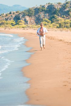 man in bright clothing runs along the beach line