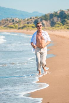 male clothed in linen, runs along the seashore