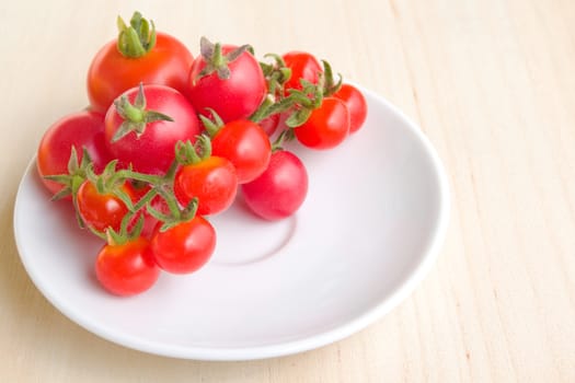 Photo shows a detail of the colourful tomatoes on a white plate.