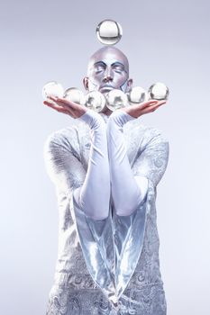 Magician with Glass Balls in Stage Makeup and Costume