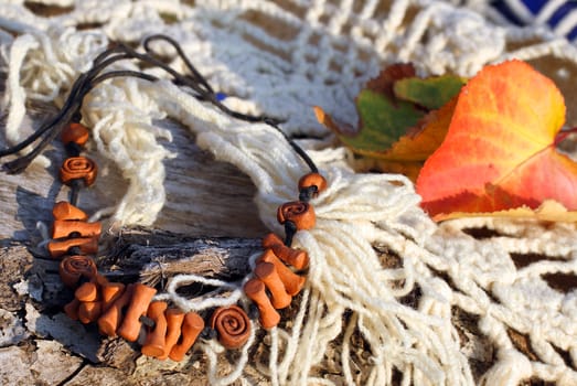 Ethnic clay necklace (bracelet) on autumn-style background