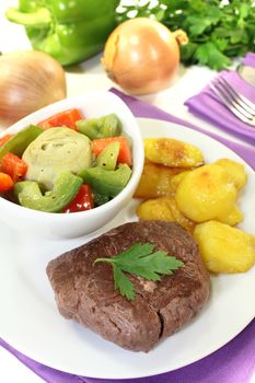 Ostrich steak with crispy baked potatoes on bright background