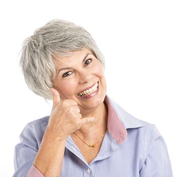 Portrait of a elderly woman making a phone call gesture 