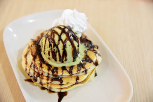 Pancake with green tea ice cream and chocolate sauce