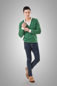 Handsome young Asian man with sweater, full length portrait isolated.