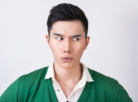 Funny facial expression, closeup Asian young man.