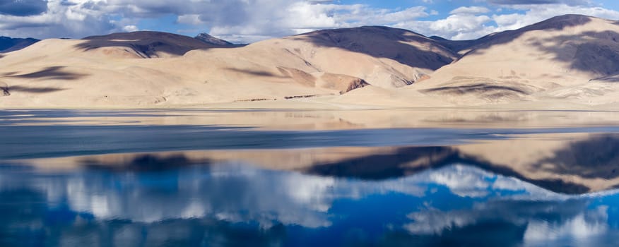 Tsomoriri mountain lake panorama with mountains and blue sky reflections in the lake (north India)