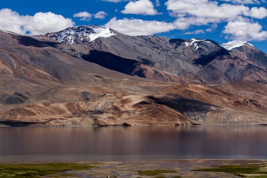 Tsomoriri mountain lake panorama with mountains and blue sky reflections in the lake (north India)