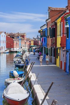 Vertical view of colorful street with canal in Burano, near Venice, Italy 