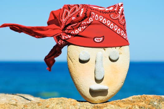 Symbol of stone head with a patterned red bandana