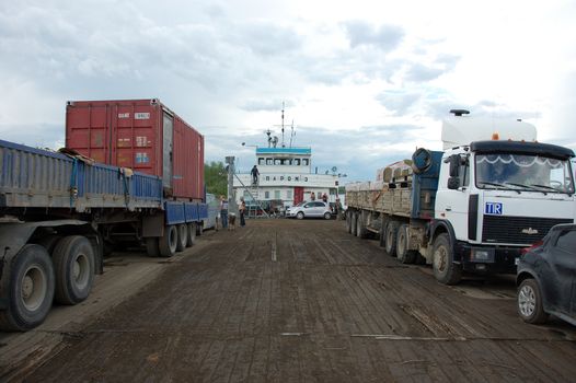 Trucks and cars at river ferry, Yakutia, outback Russia