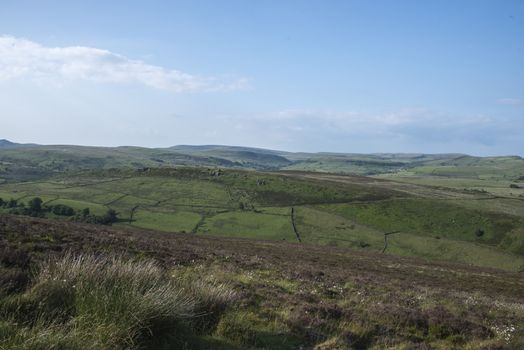 A view across fields and moorland in the Peak District National Park