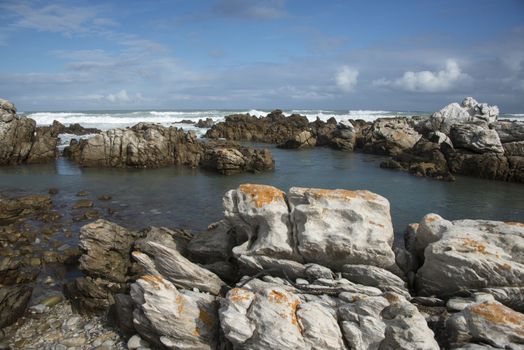 Rocks in the sea at Cape Agulhas eith waves breaking in the background