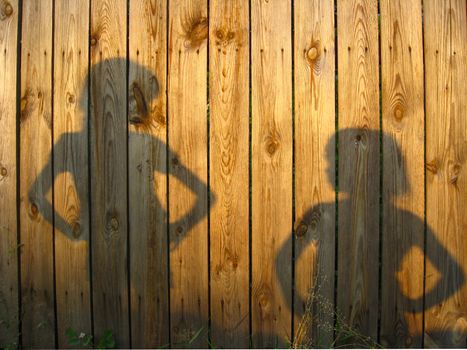 Shadow of boy and girl staring each other on wooden surface