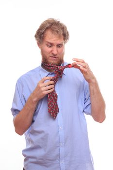 Man at morning trying to tie a tie on his neck 