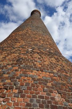 Old bottle shaped kiln made of red bricks with blue sky and clouds behind, Nettlebed, Oxfordshire, England