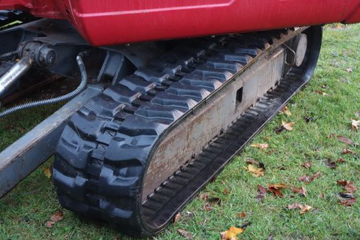 Close up of continuous track on red mechanical digger