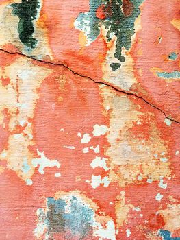 Bright cracked red wall with old peeling paint.