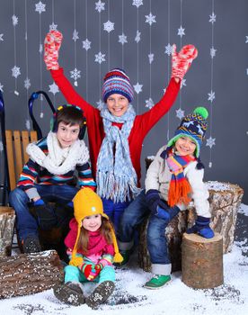 Winter Fashion. Adorable happy boys and girls in winter hat, gloves and sweater in studio.