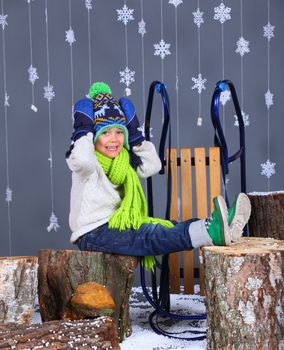 Winter Fashion. Portrait of adorable happy boy in winter hat, gloves and sweater in studio.