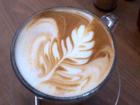 Cup of fresh latte art coffee served in a cafe