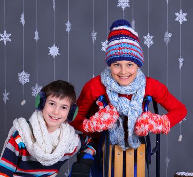 Winter Fashion. Adorable happy boy and girl in winter hat, gloves and sweater in studio.