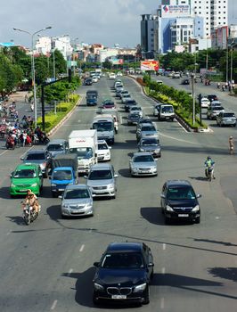  HO CHI MINH CITY, VIETNAM- JULY 3: Group of car moving in line on street, boulevard with three lane, green tree, Viet Nam, July 3, 2014