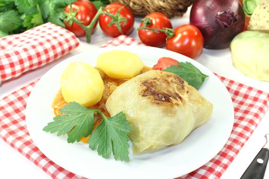 Stuffed cabbage with potatoes and parsley on a light background