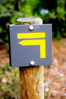 Sign indicating the direction to follow a trail for hikers