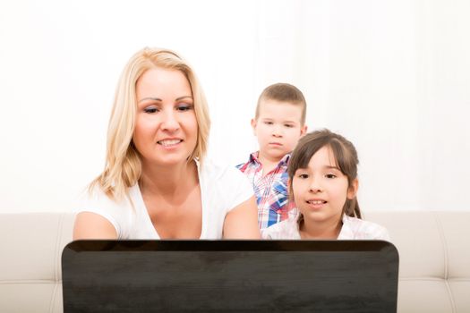 A mother using with her son and daughter a laptop computer.
