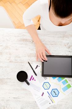 A young adult woman developing a business plan with her tablet PC at home.
