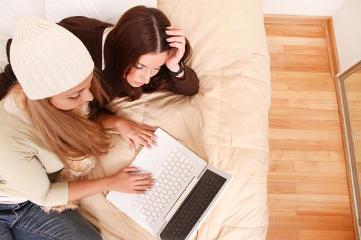 Two girls planning their winter holidays online.
