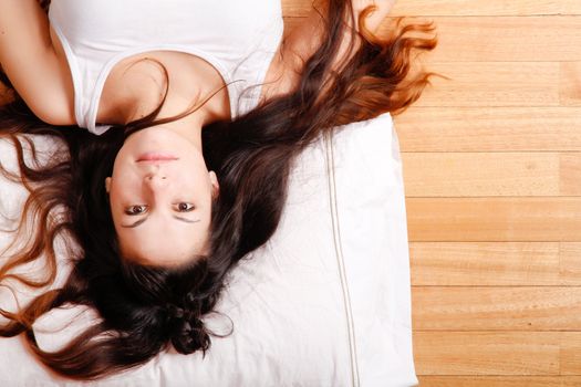 A young hispanic girl relaxing on the floor. 
