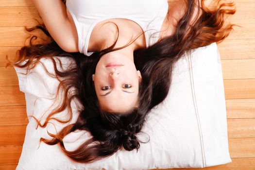 A young hispanic girl relaxing on the floor. 
