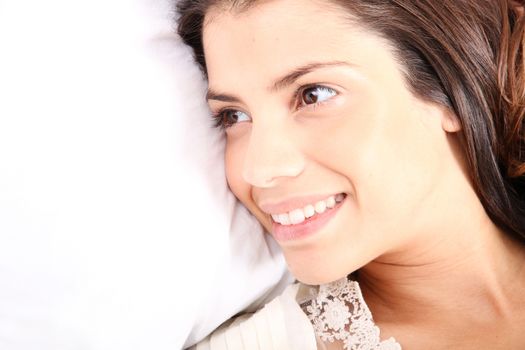 A young girl laying in bed and smiling
