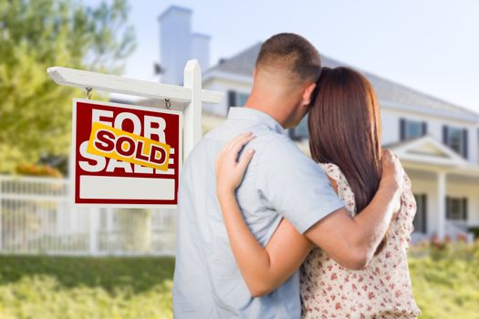 Sold For Sale Real Estate Sign and Affectionate Military Couple Looking at Nice New House.