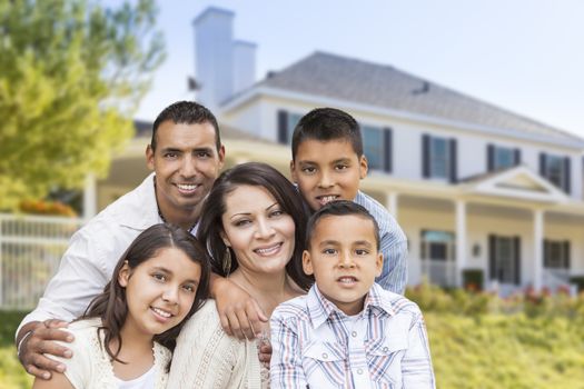 Happy Hispanic Family Portrait in Front of Beautiful House.