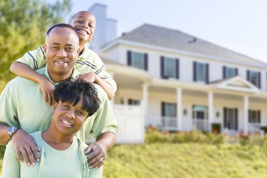 Happy Attractive African American Family in Front of Beautiful House.