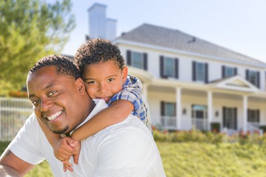 Happy Playful African American Father and Mixed Race Son In Front of House.